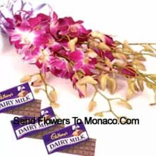 Um belo buquê de orquídeas cor-de-rosa junto com chocolates sortidos da Cadbury