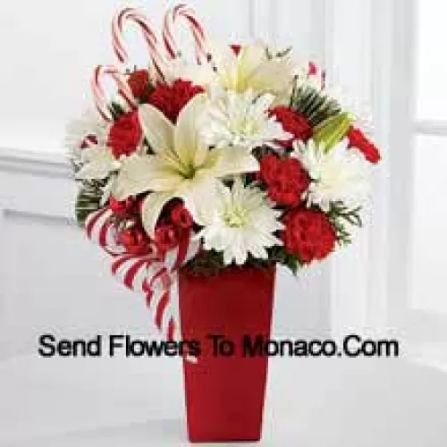 Bursts with the bright cheer and jubilant beauty of this special season. White Asiatic Lilies and chrysanthemums sit amongst red mini carnations, assorted holiday greens, red glass balls, three candy canes and festive ribbon, perfectly arranged in a red ceramic vase to create a lively bouquet of merry wishes for a splendid holiday season! (Please Note That We Reserve The Right To Substitute Any Product With A Suitable Product Of Equal Value In Case Of Non-Availability Of A Certain Product)