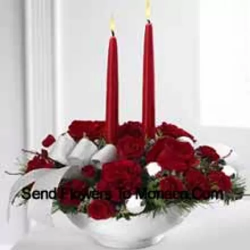 Our Holiday Elegance Centerpiece will add that special spark to their seasonal celebration with its vibrant array of crimson blooms! Red roses, carnations and spray roses sit amongst holiday greens in a posh ceramic?silver container adorned with a beautiful silver ribbon accent and two taper candles to bring a holiday glow of warmth and peace to their table. (Please Note That We Reserve The Right To Substitute Any Product With A Suitable Product Of Equal Value In Case Of Non-Availability Of A Certain Product)