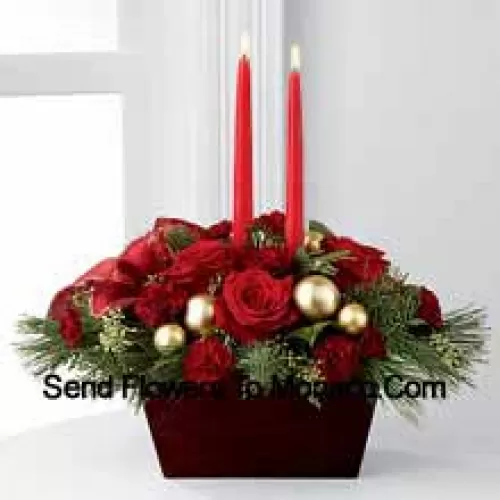 An exquisite display of holiday beauty to add warmth and cheer to their special celebrations. Rich red roses and burgundy mini carnations are set to impress surrounded by lush holiday greens, seeded eucalyptus, gold glass balls and a gold-edged red ribbon arranged elegantly around two red taper candles. Presented in a chocolate brown bamboo?container, this centerpiece will usher in joy and goodwill with each treasured bloom (Please Note That We Reserve The Right To Substitute Any Product With A Suitable Product Of Equal Value In Case Of Non-Availability Of A Certain Product)